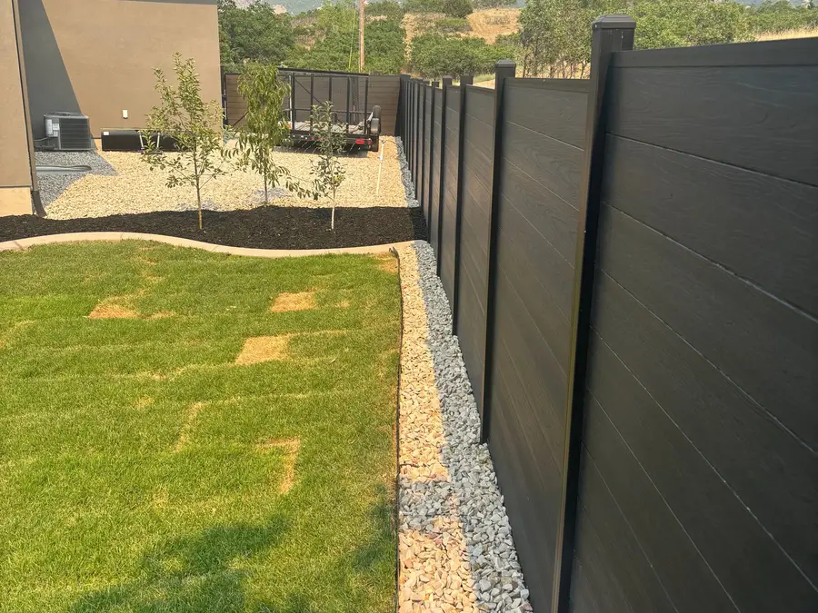 Black privacy fence along fresh sod with mountains in the distance