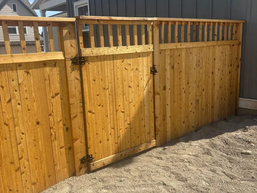 Cedar fence and gate beside a newly built home