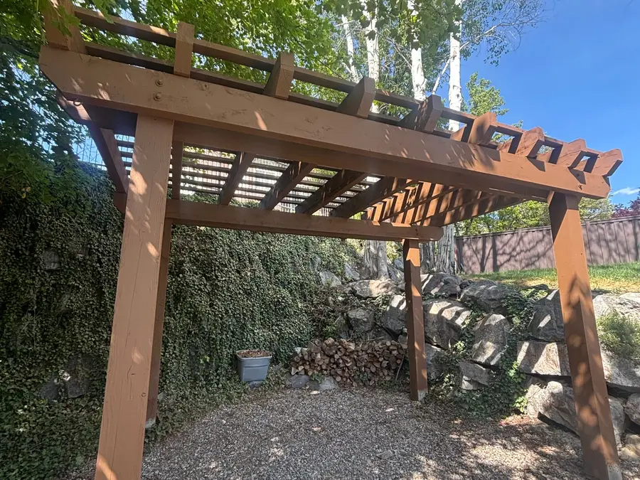 Cedar pergola in afternoon light over a gravel floor