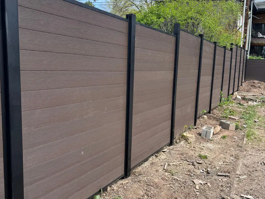 Composite privacy fence running down a hillside lot