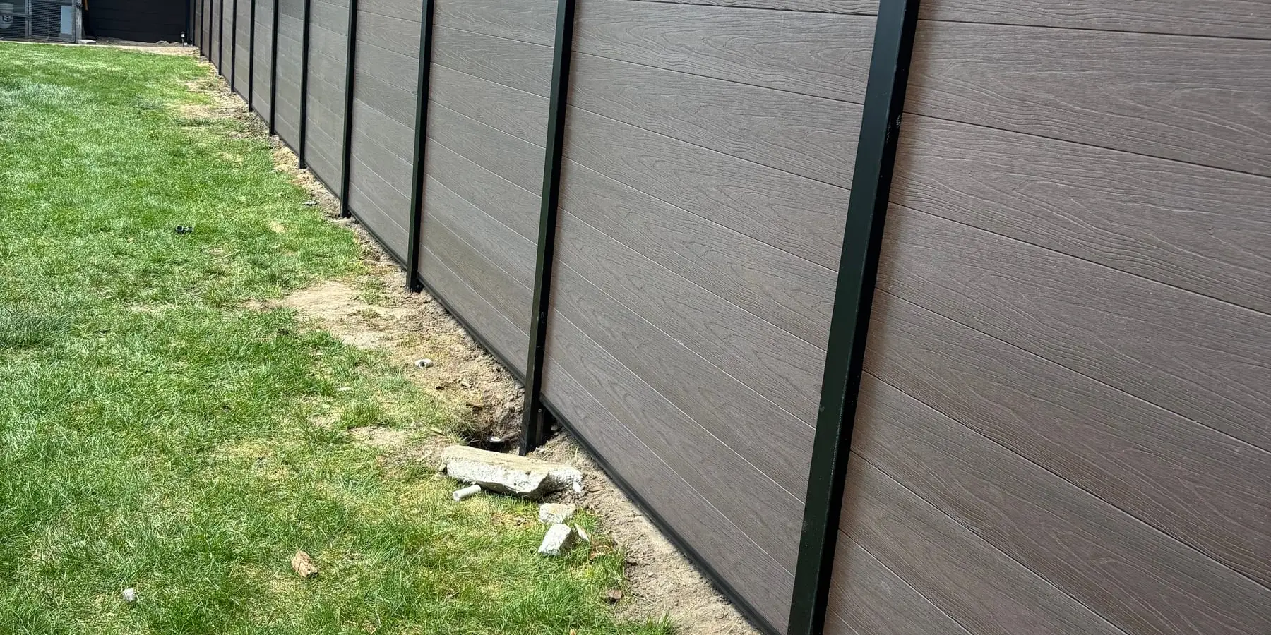 End view of a composite privacy fence along a lawn
