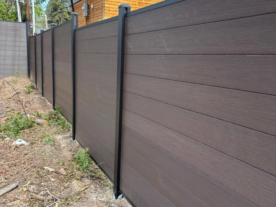 Composite privacy fence with a modern two-story home behind it