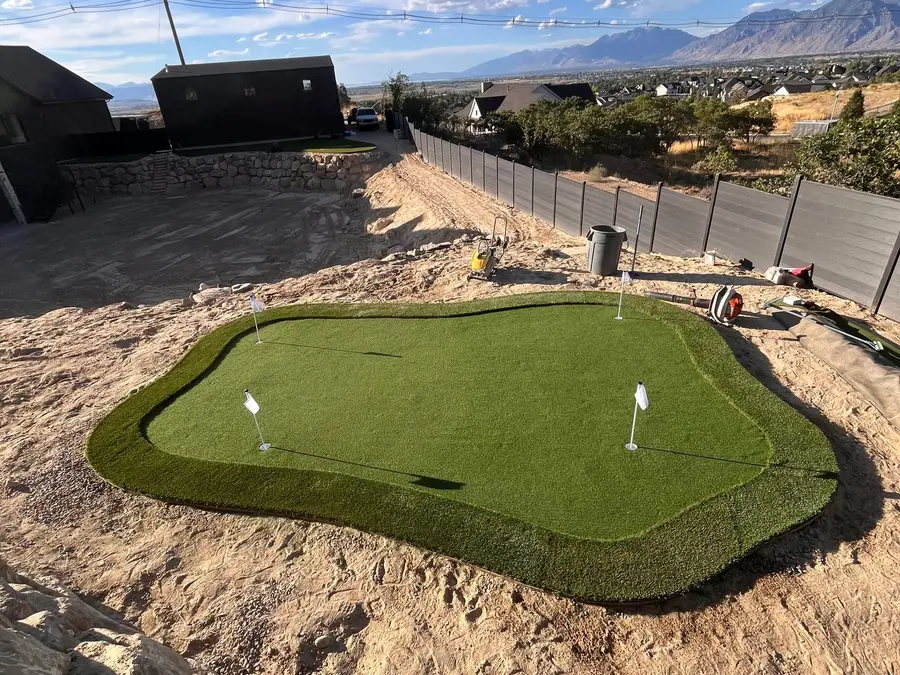 Backyard putting green being installed with mountains in the distance
